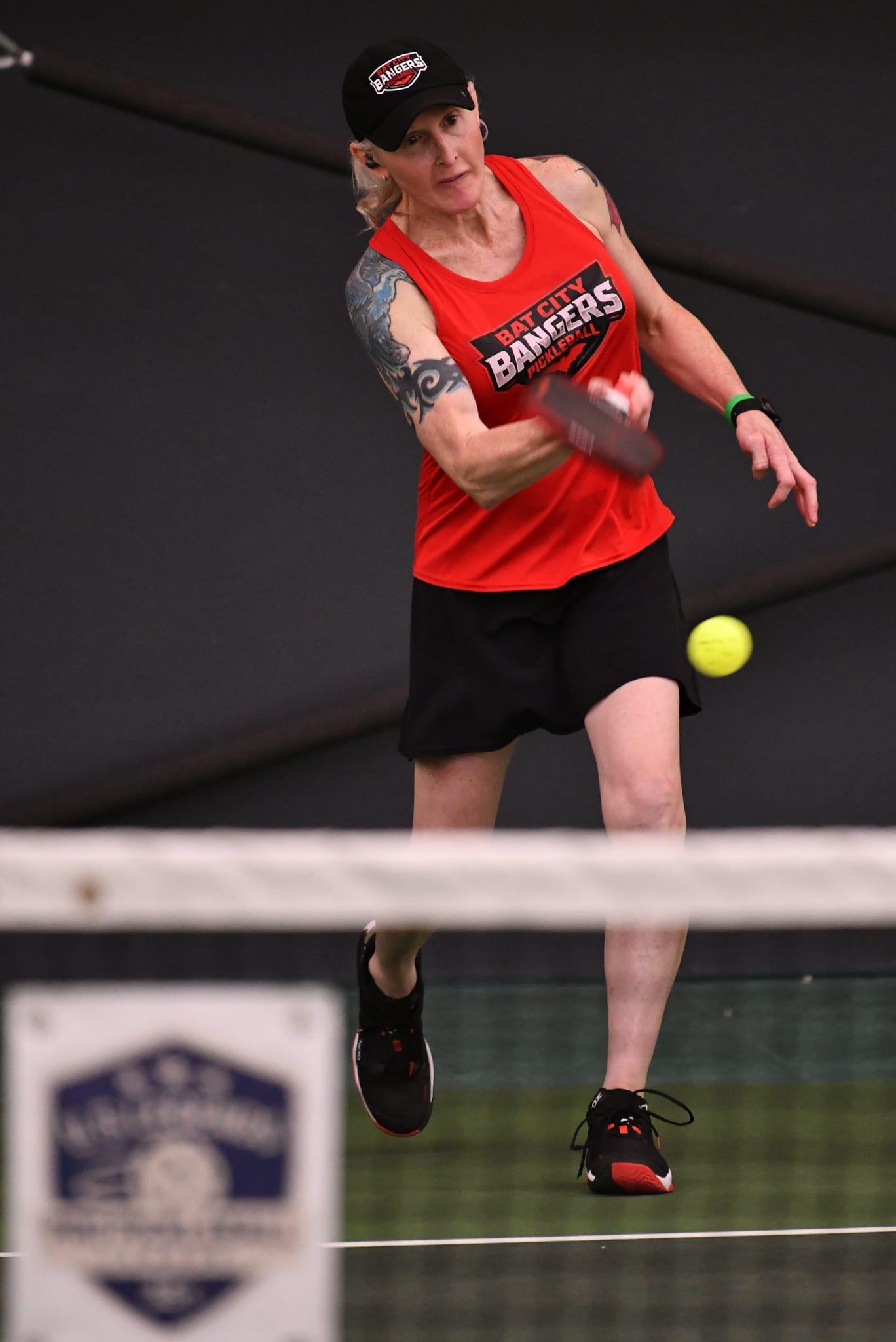 Madeline Eden firing a forehand